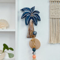 Decorative wall hook with palm tree design on a white wall