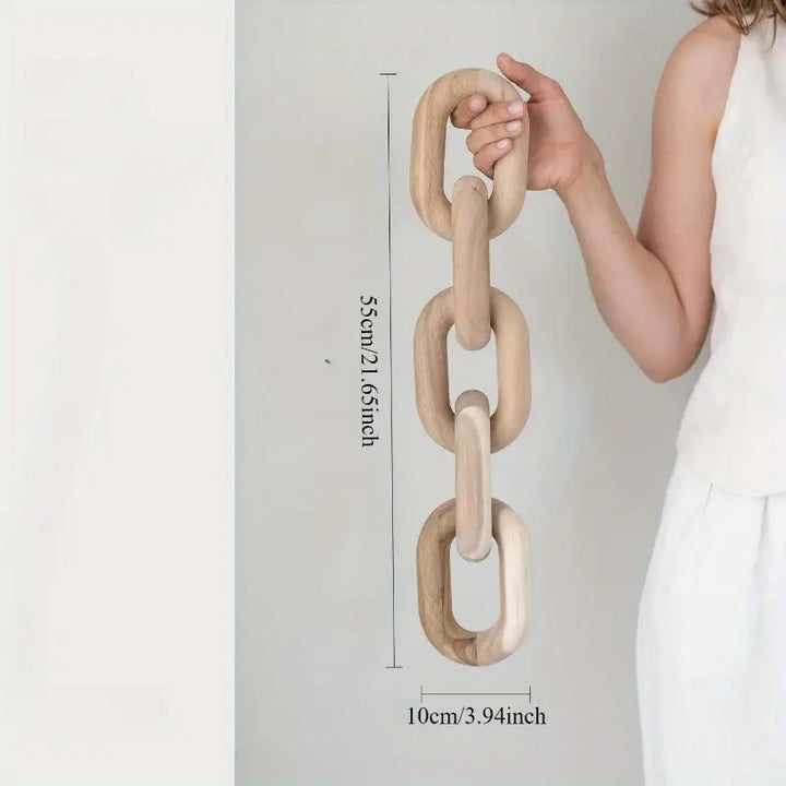 Person holding a large wooden chain with measurements displayed