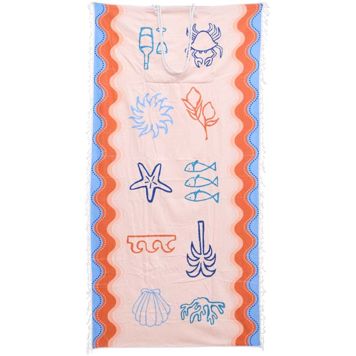Mediterranean beach towel with vibrant blue and pink tropical print laid out flat on sand, quick-drying microfibre material.