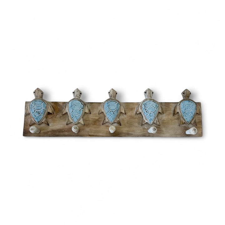 Wooden coat rack with turtle decorations on a white background