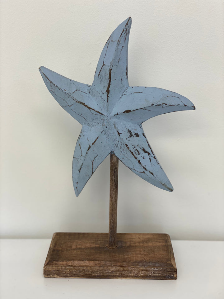 Blue wooden starfish sculpture on stand