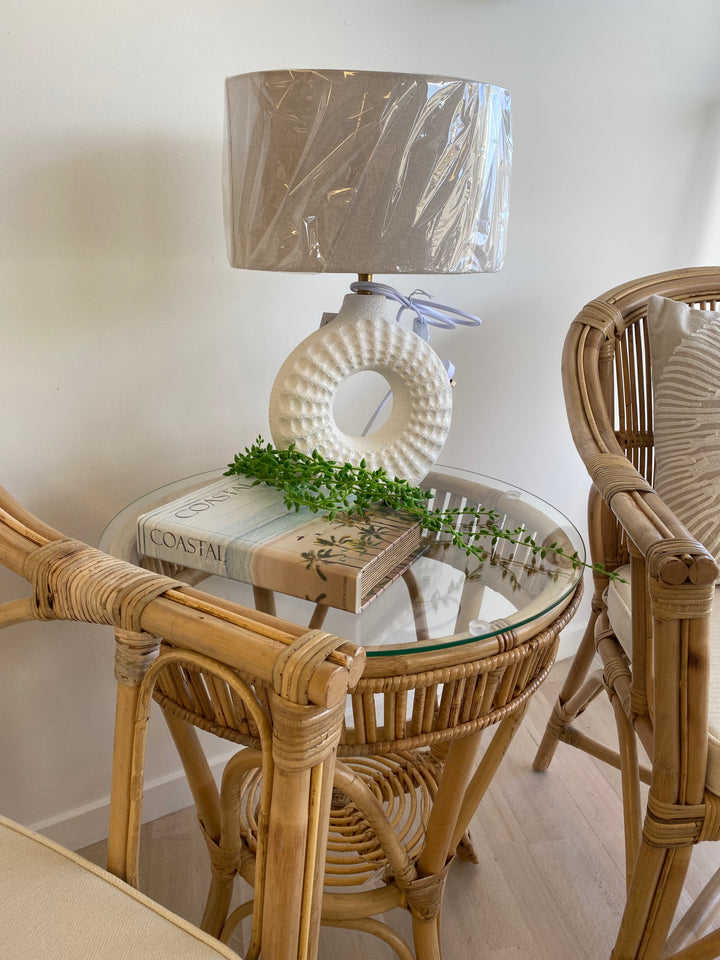 table lamp with a textured white base and beige fabric shade