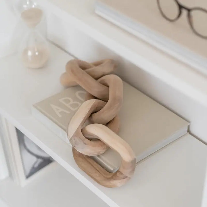 Wooden knot toy on a shelf with a neutral background