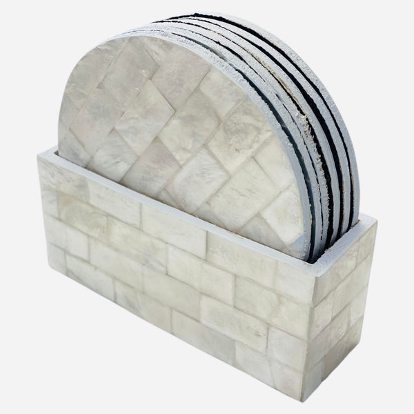 Set of shell coasters in a holder on a white background