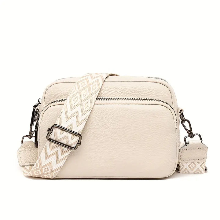Beige crossbody bag with a patterned strap