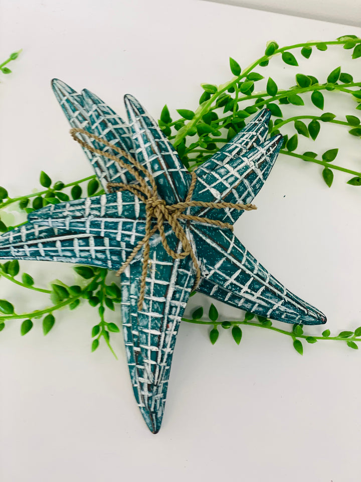 Decorative star with grid pattern and twine on a white background with green leaves.