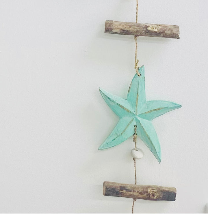 Decorative star hanging on a white wall with wooden elements