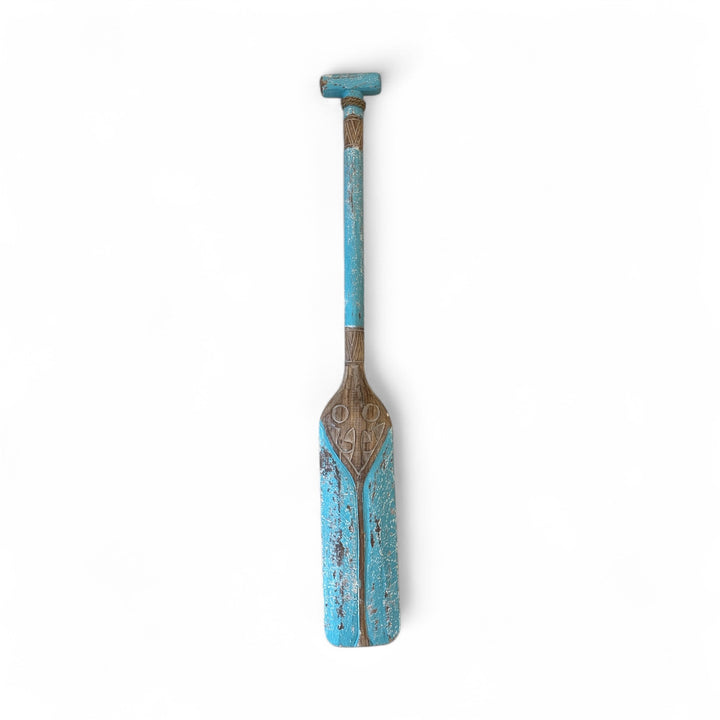 Wooden paddle with blue and brown design on a white background