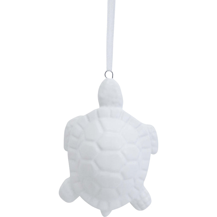 White turtle-shaped ornament hanging on a white background