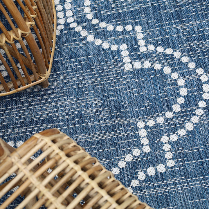 Close-up of a blue textured surface with white patterns and two wicker baskets.