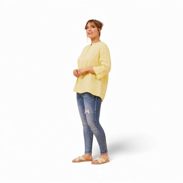Woman wearing a yellow top and blue jeans on a white background