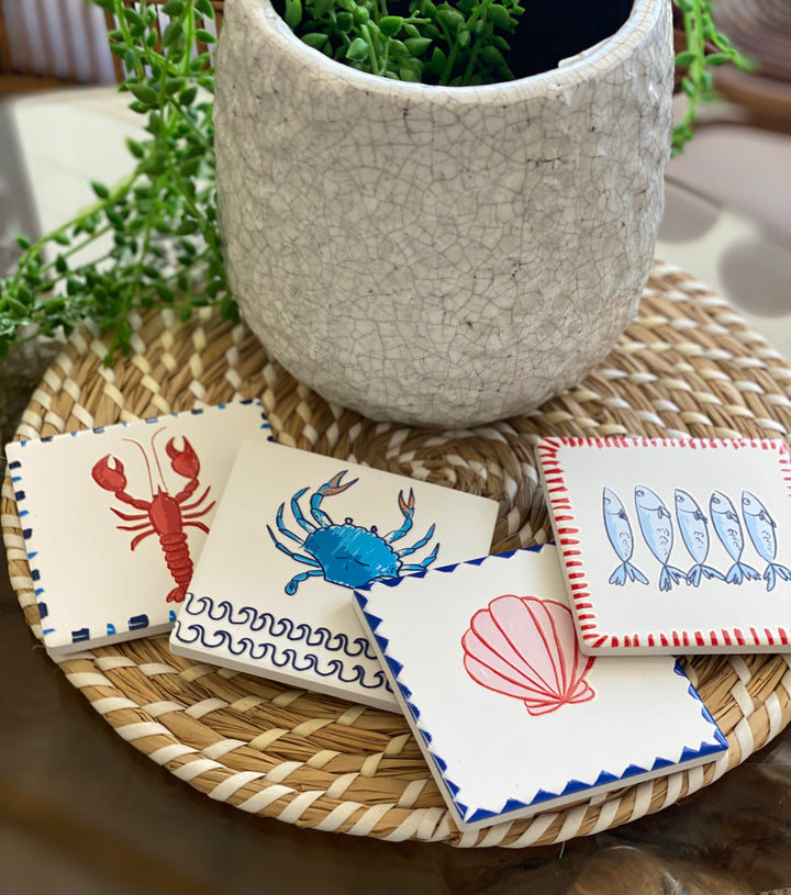 Set of four coasters with mediterranean themed designs on a white background