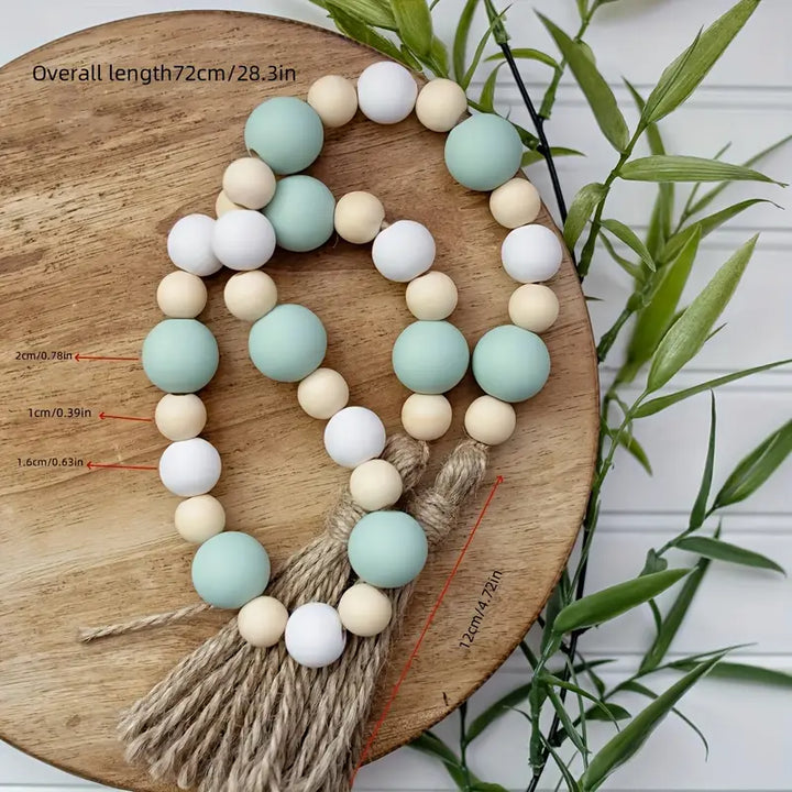 Decorative  pastel beads and tassel on a wooden board with measurements.