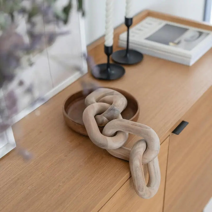 Decorative chain on a wooden surface with a blurred background