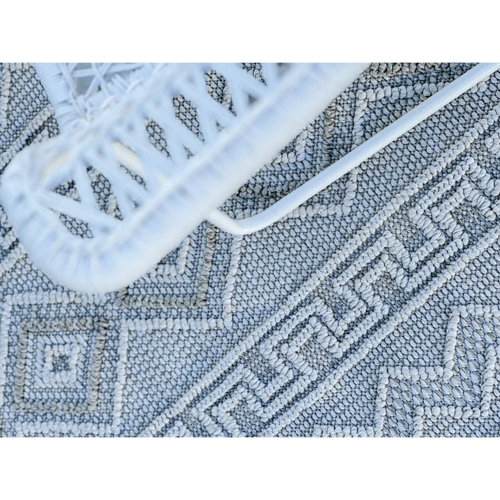 Close-up of a textured rug with geometric patterns and a white border.