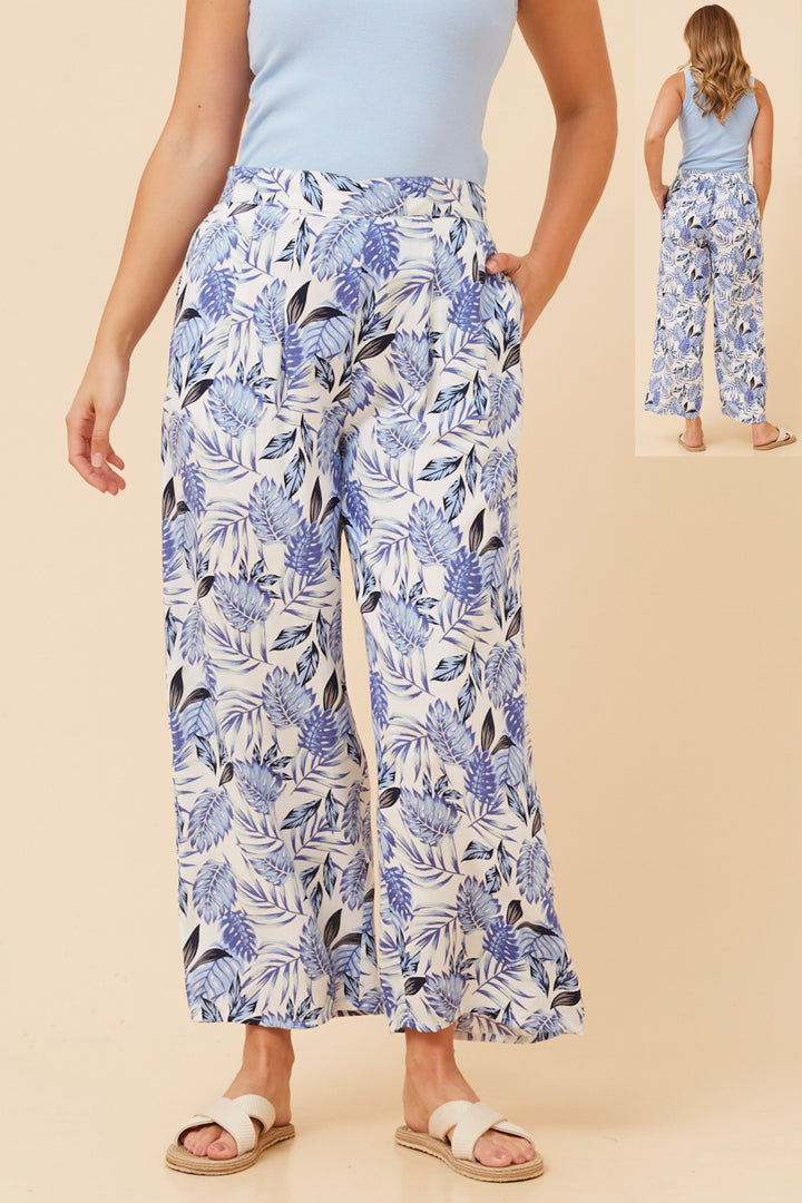 Woman wearing blue floral pants on a beige background