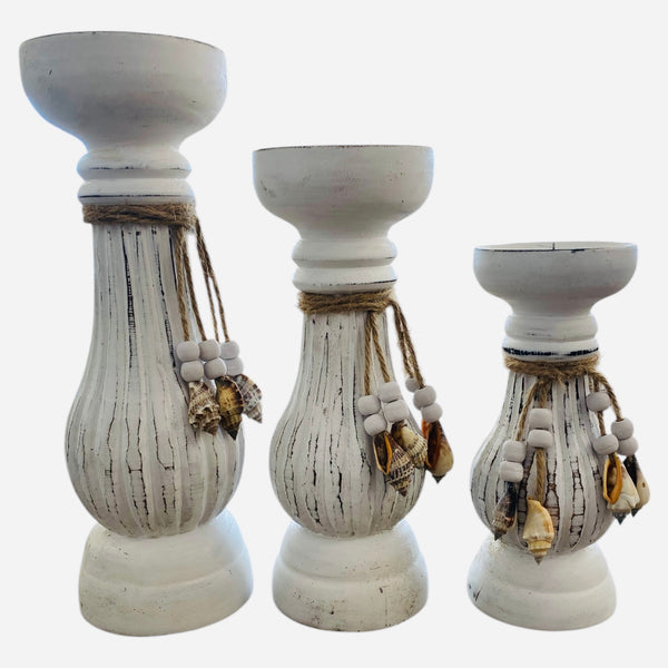 Three whitewash pillar candle holders with decorative elements on a white background