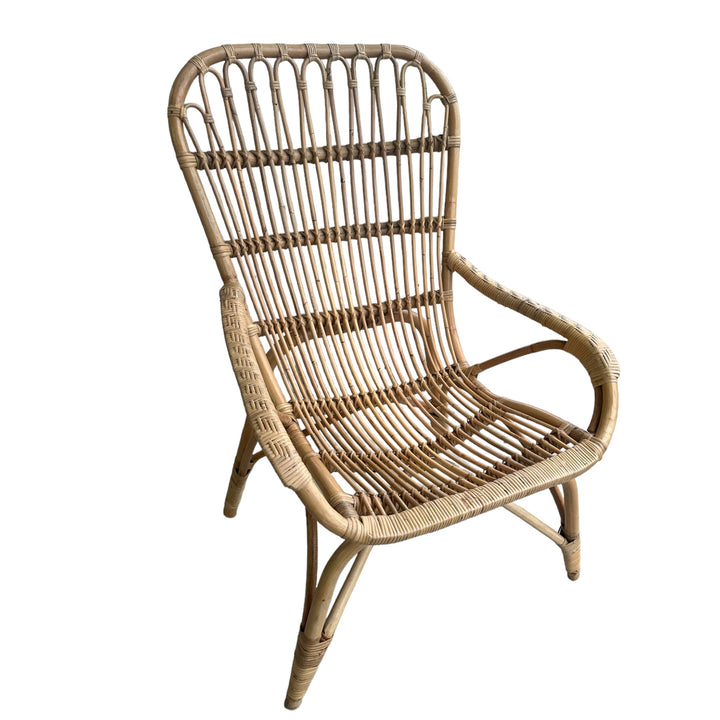 Natural cane lounge chair with curved lines and a relaxed handcrafted design