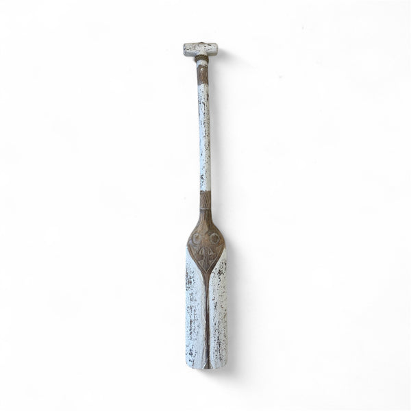 Decorative paddle with a rustic design on a white background