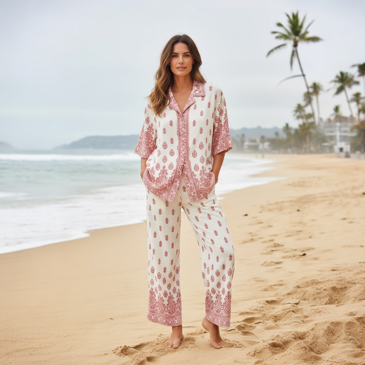 Woman wearing a red and white boho print rayon set on the beach, featuring a button-down shirt and wide-leg pants