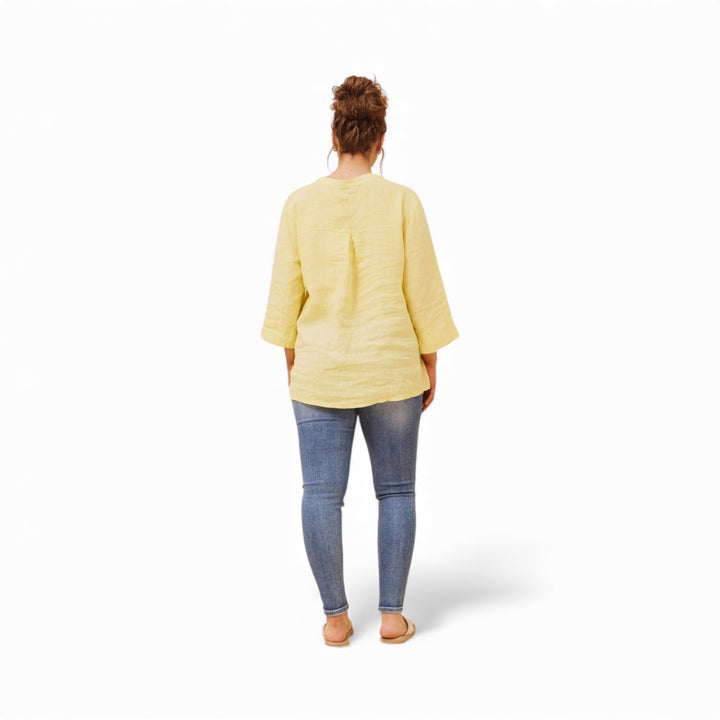 Person wearing a yellow top and blue jeans on a white background
