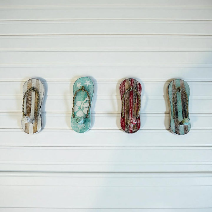 Small timber wall hook shaped like a flip flop, handcrafted coastal décor piece perfect for hanging towels, keys, or accessories in a beach-style home