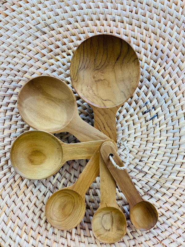 Set of wooden measuring spoons on a woven surface