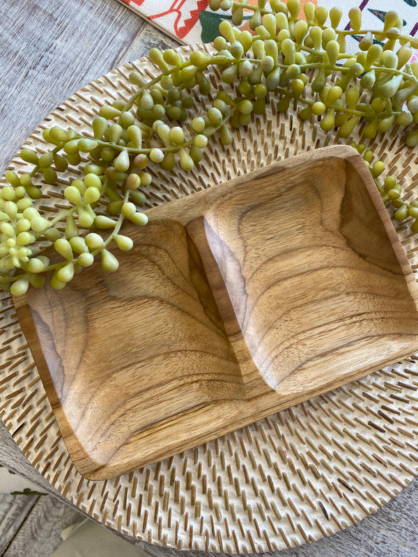 Wooden condiment dish for easy entertaining with greenery on a textured surface