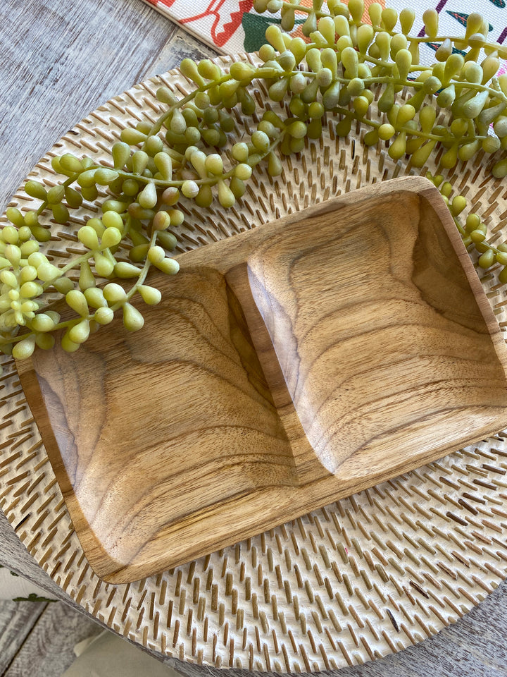 Wooden condiment dish for easy entertaining with greenery on a textured surface