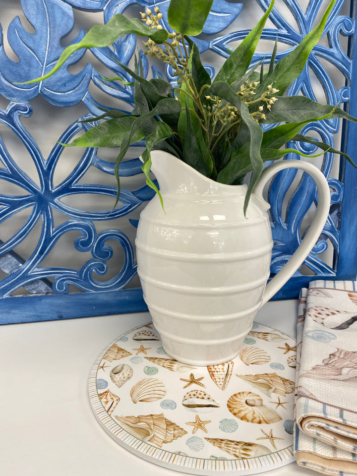 Round beach trivet or placemat with shell and starfish pattern on a white background