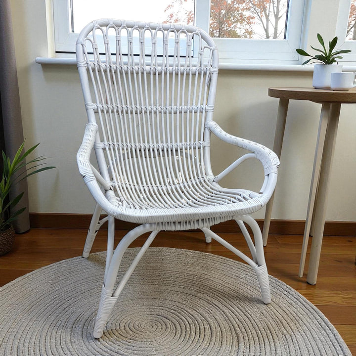 White rattan lounge chair with curved back and armrests, handcrafted, perfect for coastal, country or contemporary styles