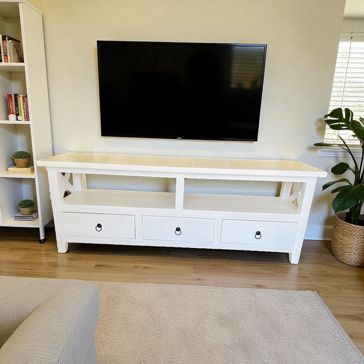 White TV stand with a black flat-screen TV in a living room setting.