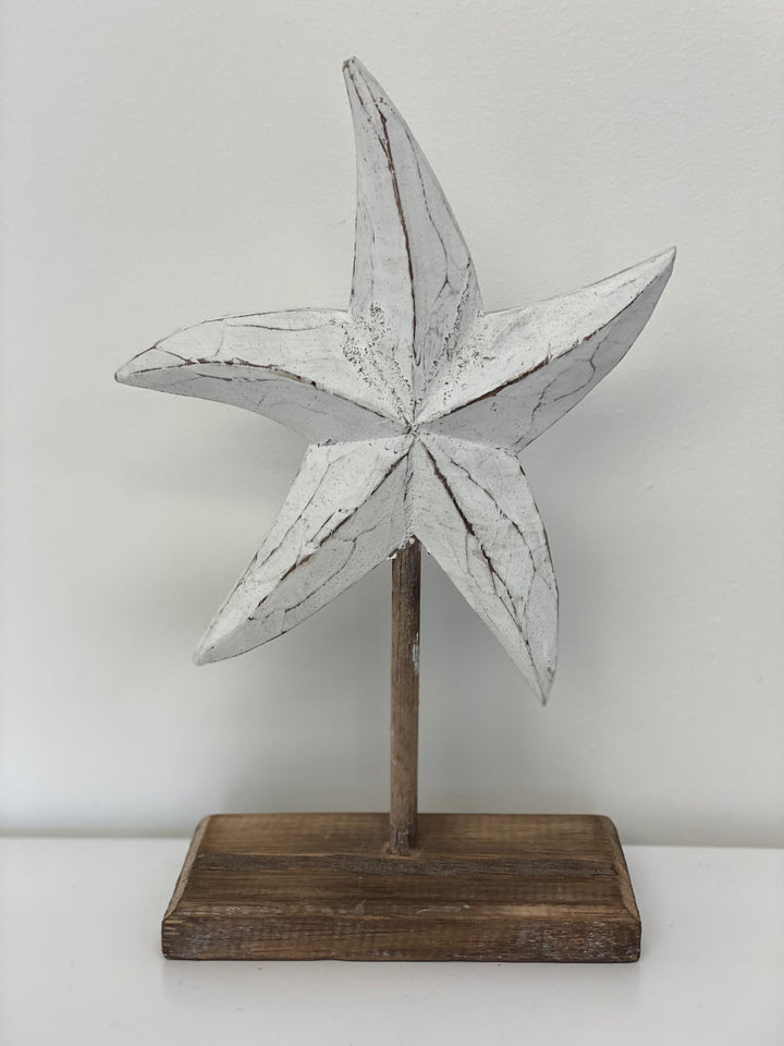 White wooden starfish sculpture on a stand