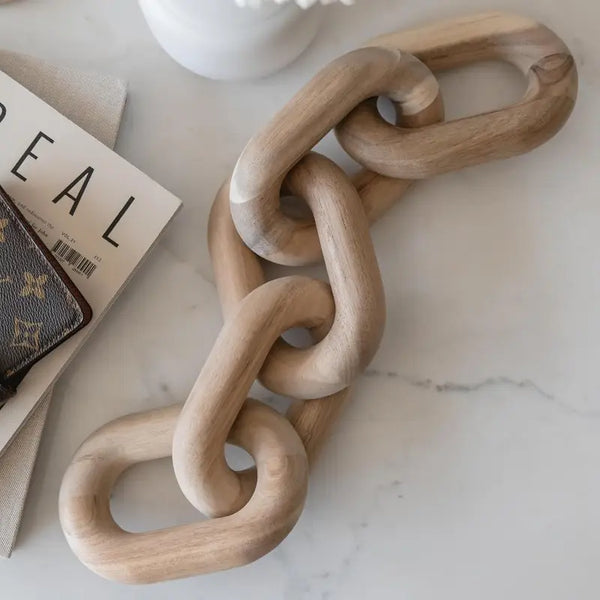 Wooden chain on a marble surface with a magazine and wallet in the background