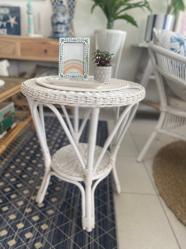 White cane side table suited for indoors or outdoors
