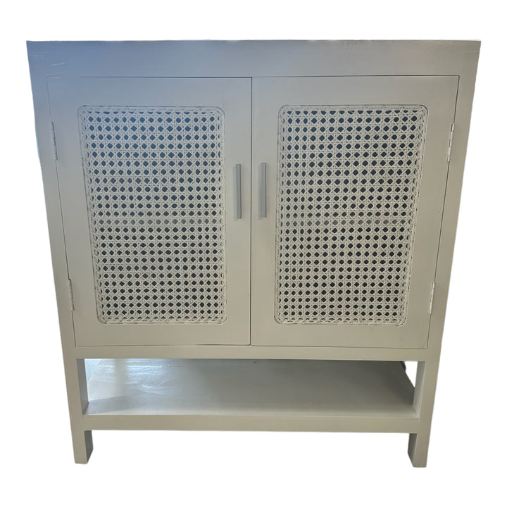 White two-door cabinet with rattan mesh inlay on the doors, featuring a clean, modern finish and subtle texture contrast